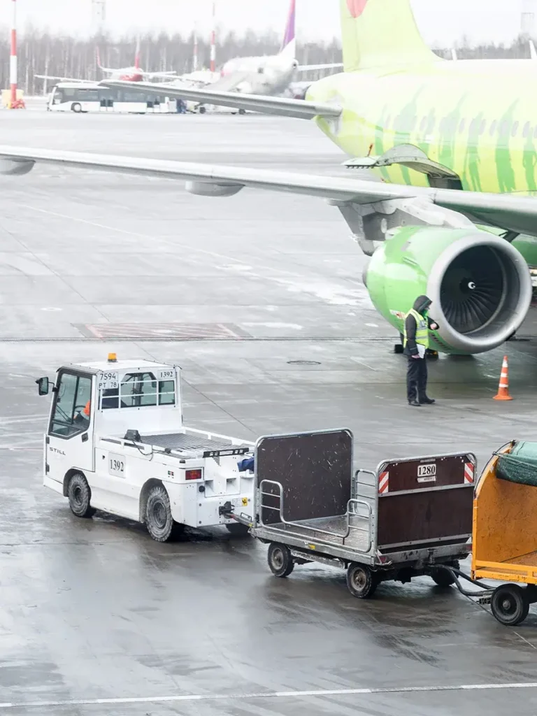 HxGN EAM for Fleet Management - an aircraft and a car with trolleys on an airport